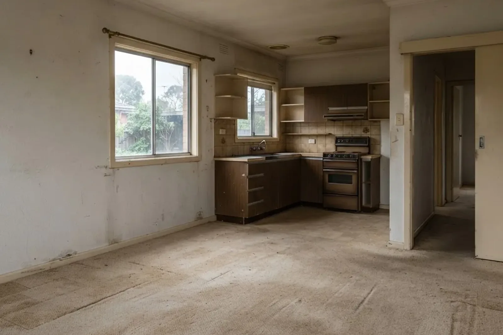 Dark, closed-in original living room before renovation, with low ceilings and a small window